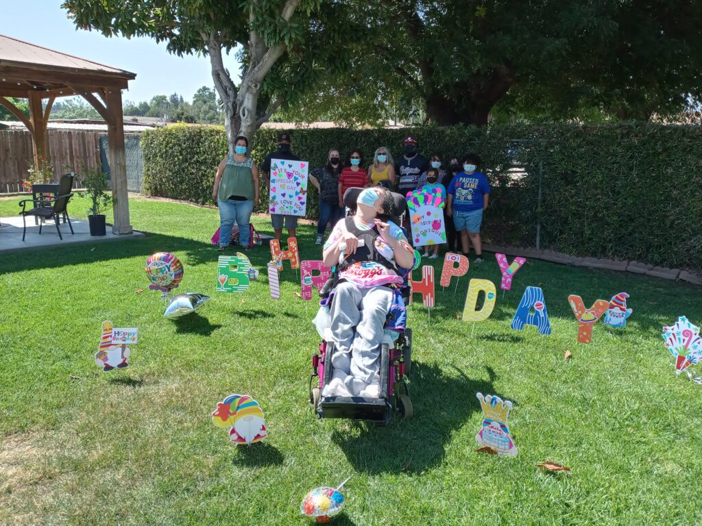 A woman in a wheelchair surrounded by happy birthday signs.