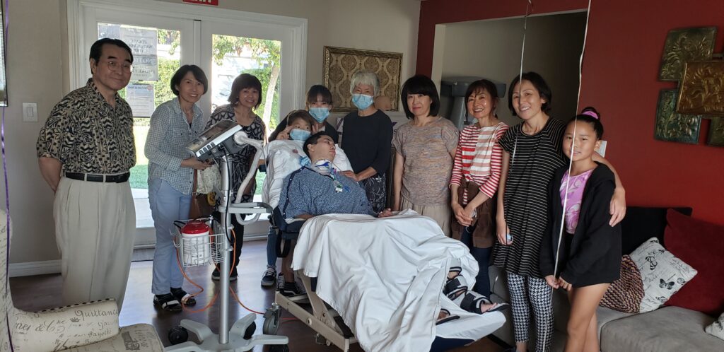 A group of people standing around a hospital bed.