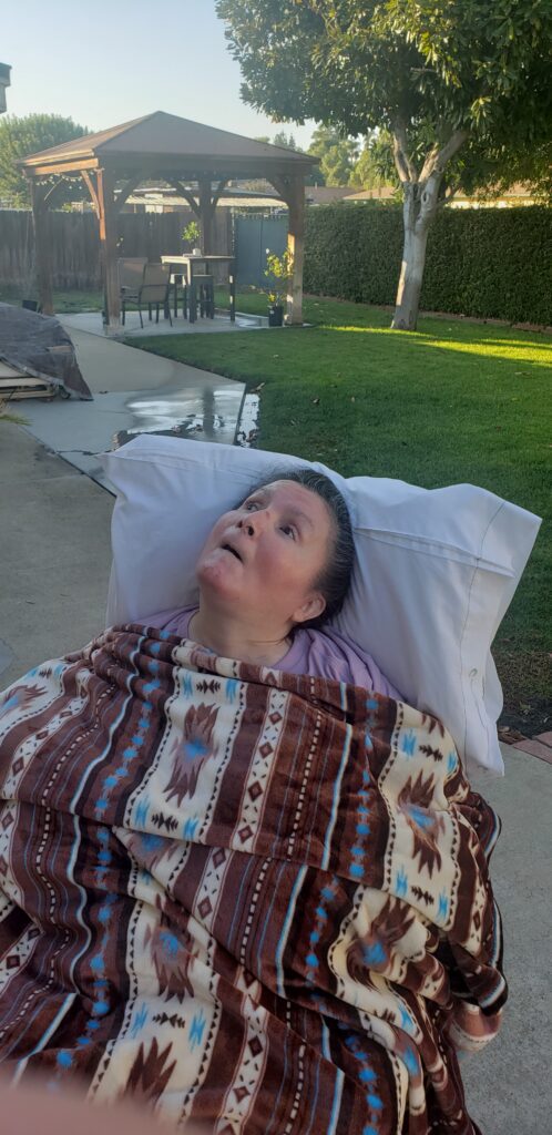 A woman laying in bed with a blanket over her head.